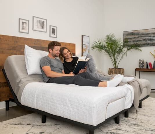 a couple sitting on an adjustable bad and reading book