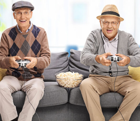 two older man playing kids game on the sofa