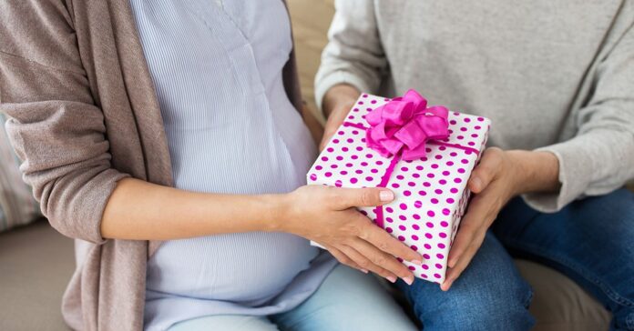 close up of man giving present to pregnant wife