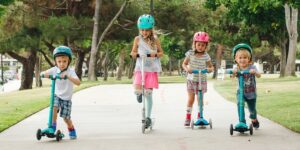 four kids on scooters in park