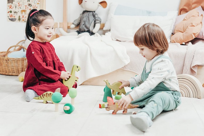 picture of a girl and a boy playing with wooden toys