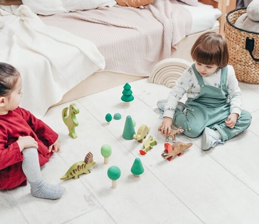 picture of kids sitting on the ground and playing with toys