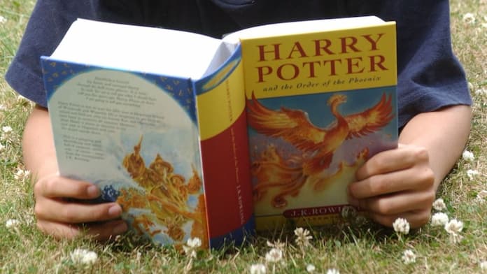 kid reading Harry Potter book