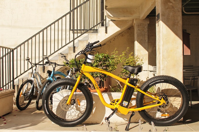 yellow electric bicycle in front of stairs 