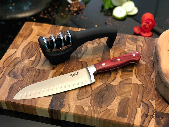 picture of a knife and sharpner on a wooden chopping board