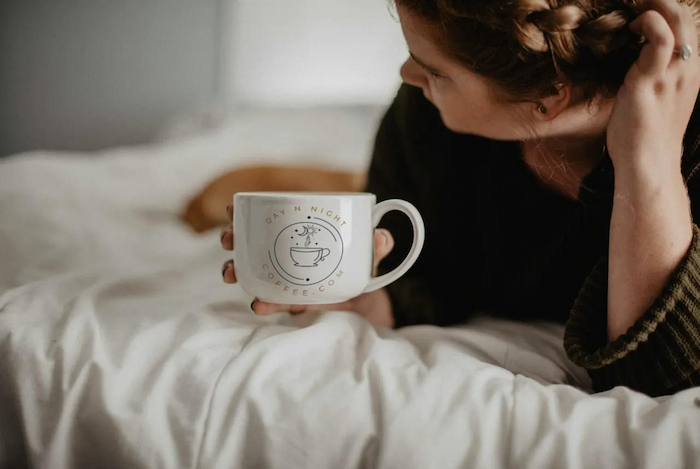 girl laying with cup of coffee