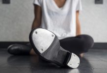 picture of woman sitting on the floor wearing tap dance shoes