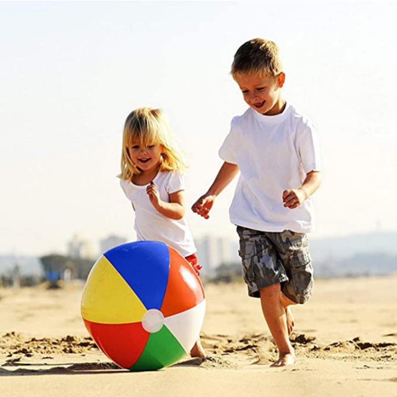 Two kids playing on the beach with beach ball