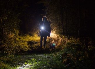 picture of a person in the dark outside holding a search and rescue flashlight