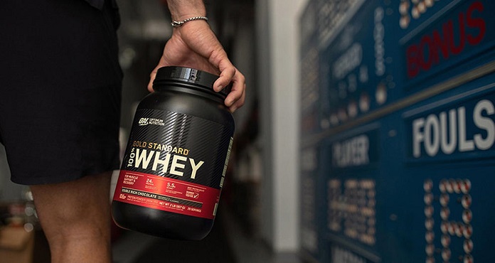 person holding a gold standard whey protein