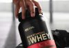person taking out gold standard whey protein from a gym bag
