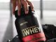 person taking out gold standard whey protein from a gym bag