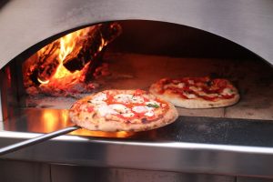 baking pizza in a pizza oven outdoors