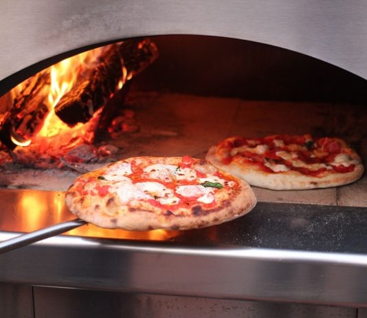 baking pizza in a pizza oven outdoors