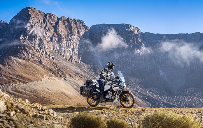 Man riding CF Moto with accessories on mountain