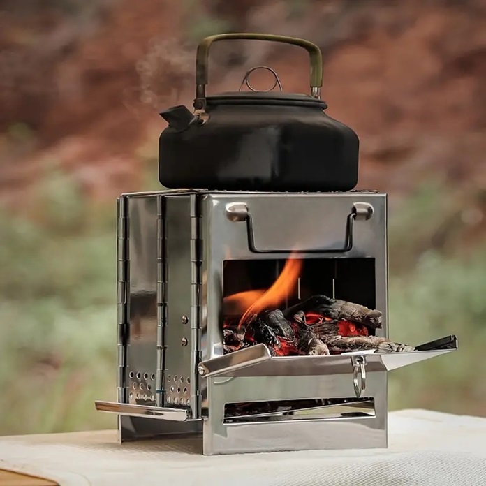 A black portable camping stove and wood burning inside